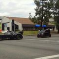 the batmobile being chased by a smart car being chased by a lamborghini aventador